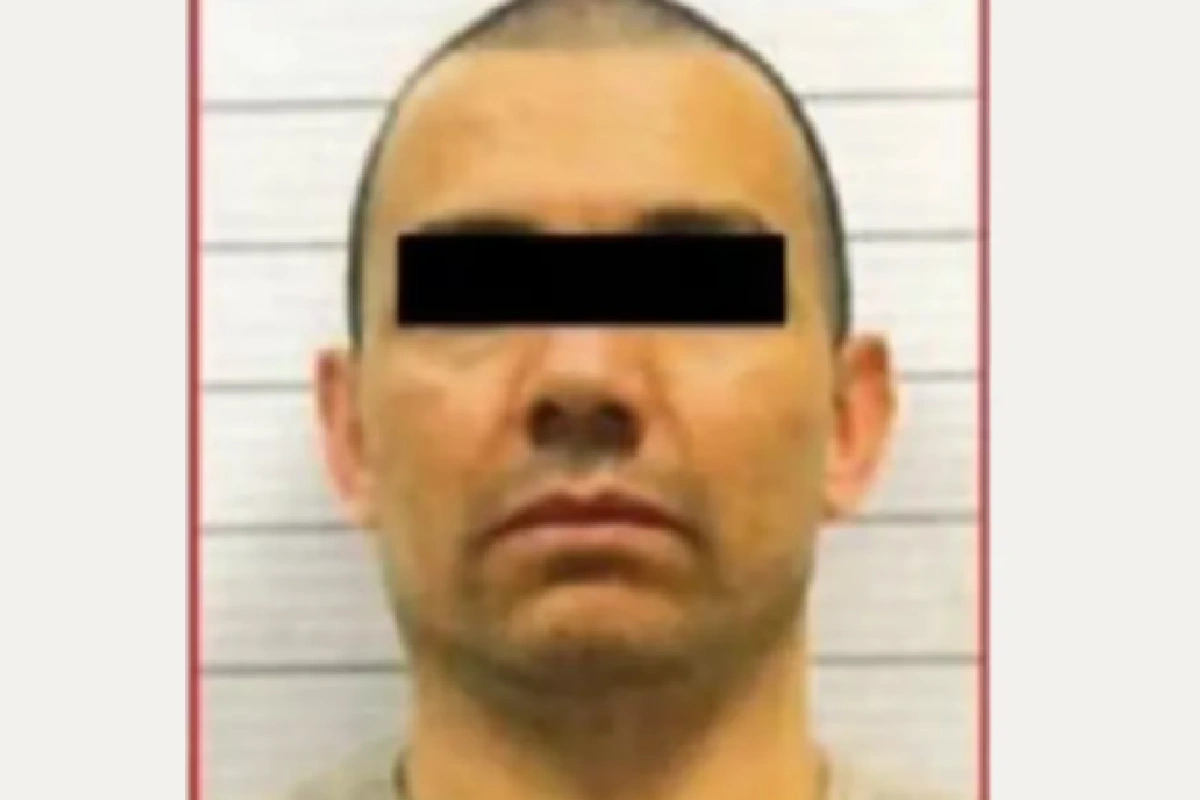 Fotografía oficial de ficha de detención de un hombre con el cabello rapado y los ojos cubiertos por una barra negra de censura.