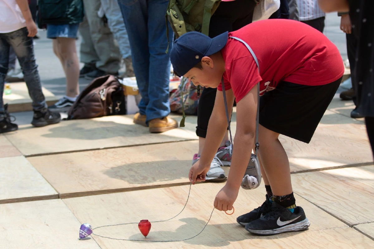 Un niño jugando con un trompo