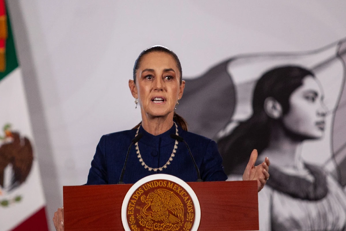Presidenta claudia sheinbaum hablando en conferencia de prensa matutina con la bandera de México atrás