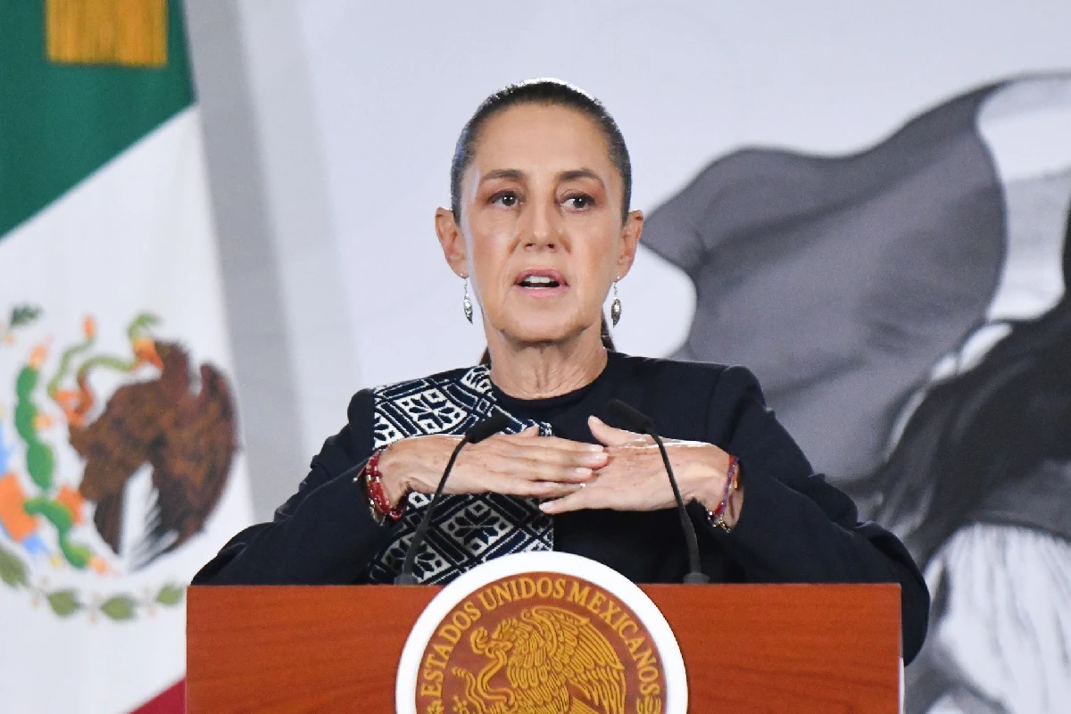 Claudia Sheinbaum hablando desde un podio con el escudo nacional de México durante una conferencia de prensa oficial.
