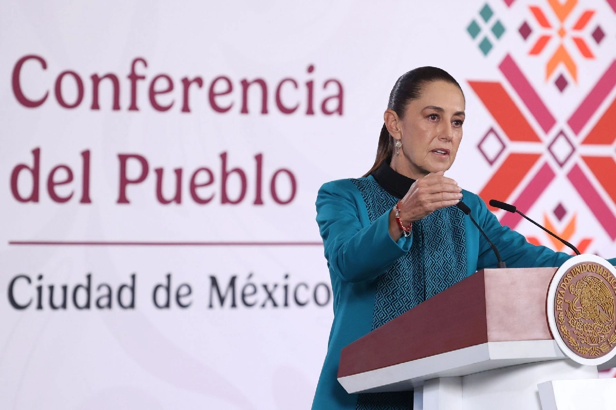 La presidenta Claudia Sheinbaum hablando y de fondo la imagen de conferencia del pueblo
