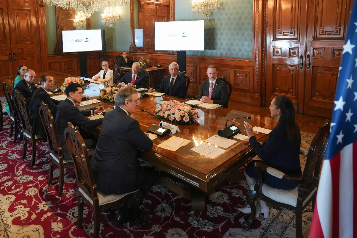 La presidenta Claudia Sheinbaum encabeza una reunión de trabajo con la delegación comercial de EE. UU. y funcionarios mexicanos alrededor de una mesa de conferencias en Palacio Nacional.