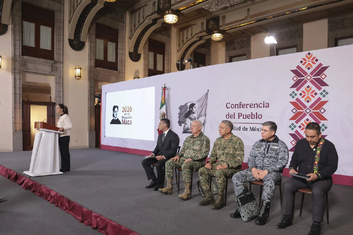 La presidenta Claudia Sheinbaum encabeza la "Conferencia del Pueblo" desde el podio, acompañada en el escenario por el Gabinete de Seguridad e mandos militares sentados a un costado.