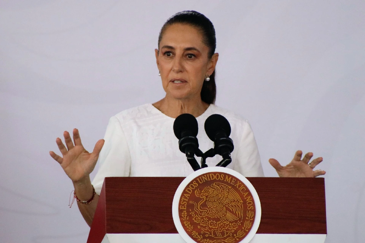 La presidenta Claudia Sheinbaum gesticulando mientras habla desde el podio presidencial con el escudo de Estados Unidos Mexicanos.