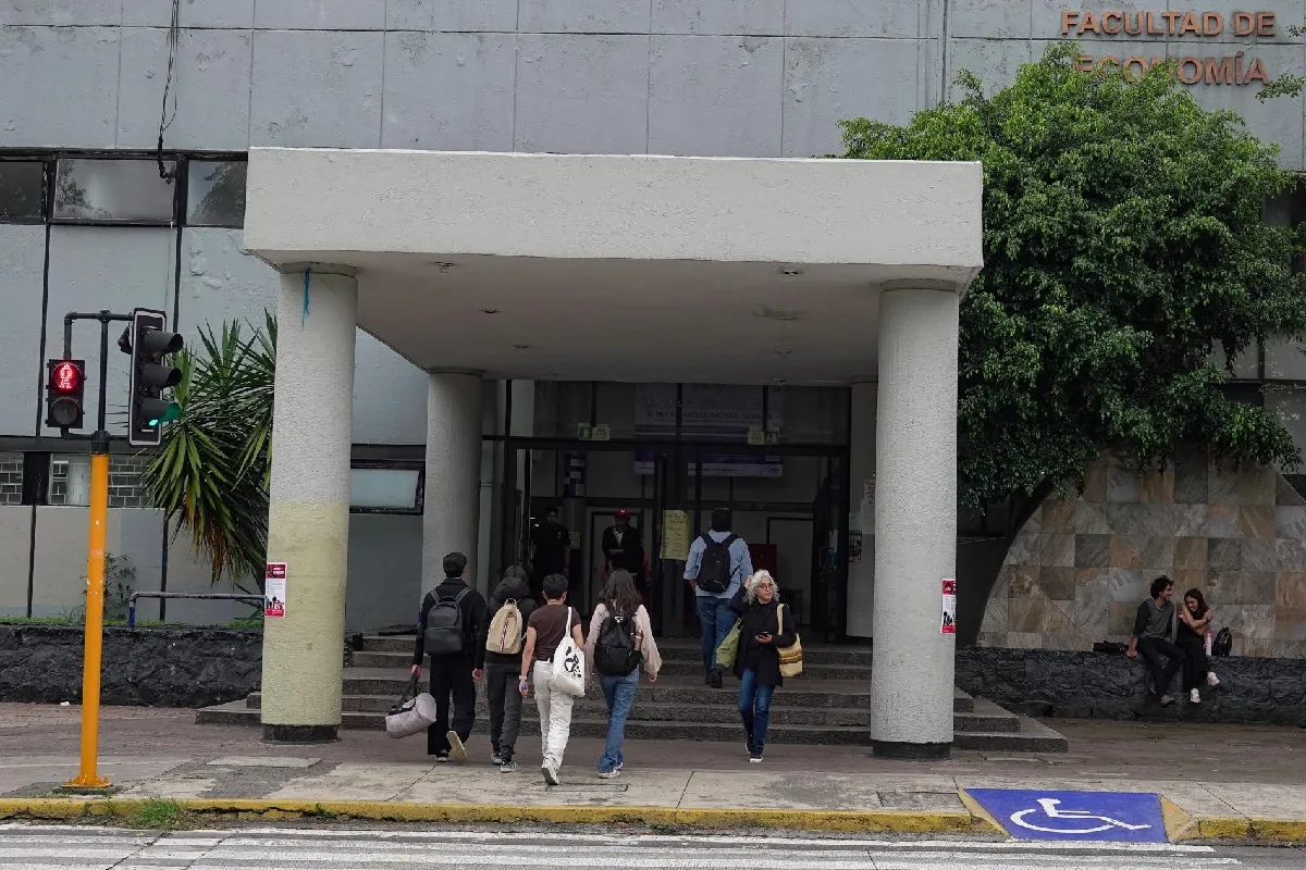 Entrada principal de la Facultad de Economía de la UNAM con estudiantes subiendo las escaleras del pórtico.