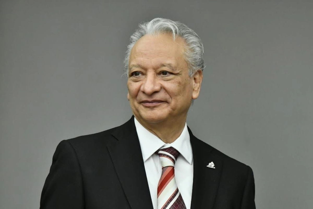 Víctor Rodríguez Padilla, exdirector de Pémex, con un fondo gris detras de él sonriendo y vestido de traje