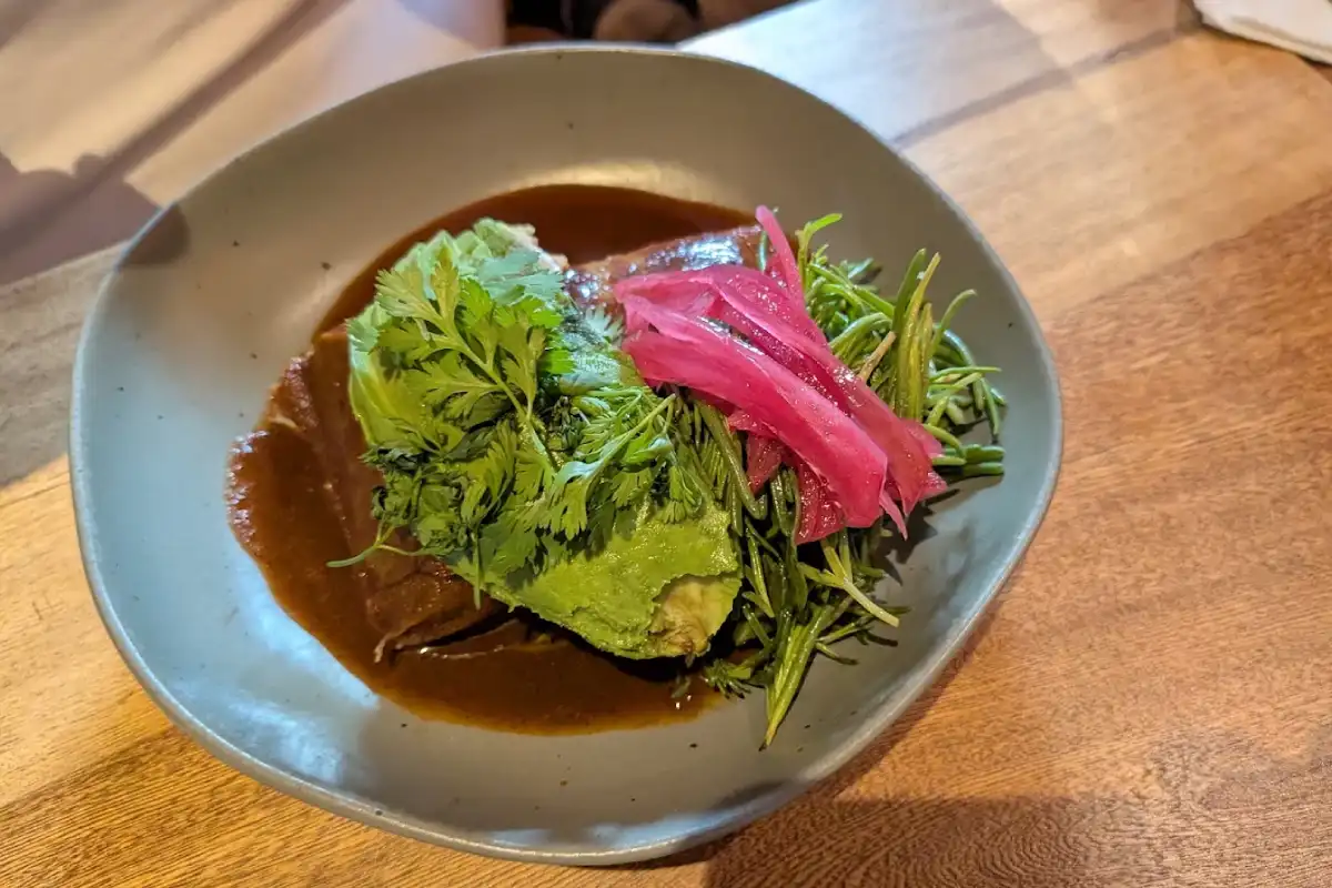 Enfrijoladas con aguacate y cebollas encurtidas