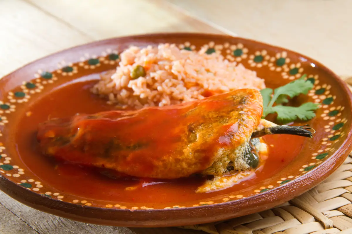 Plato de barro con chile relleno y arroz rojo