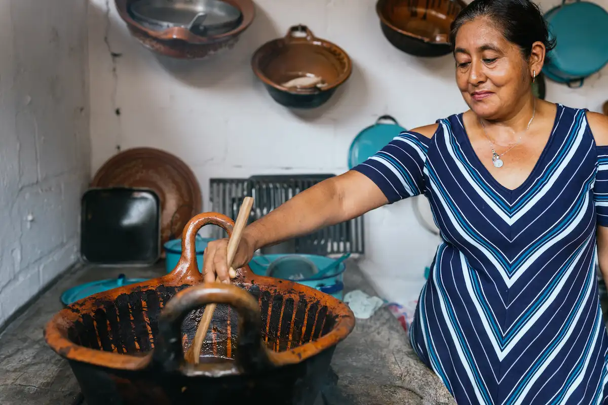 cocinera tradicional prepara mole en olla de barro