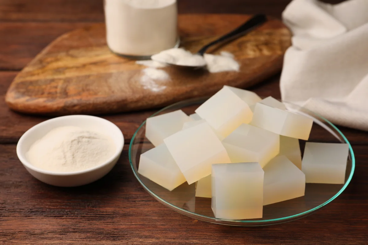 Cubos y polvo de gelatina de agar-agar sobre mesa de madera