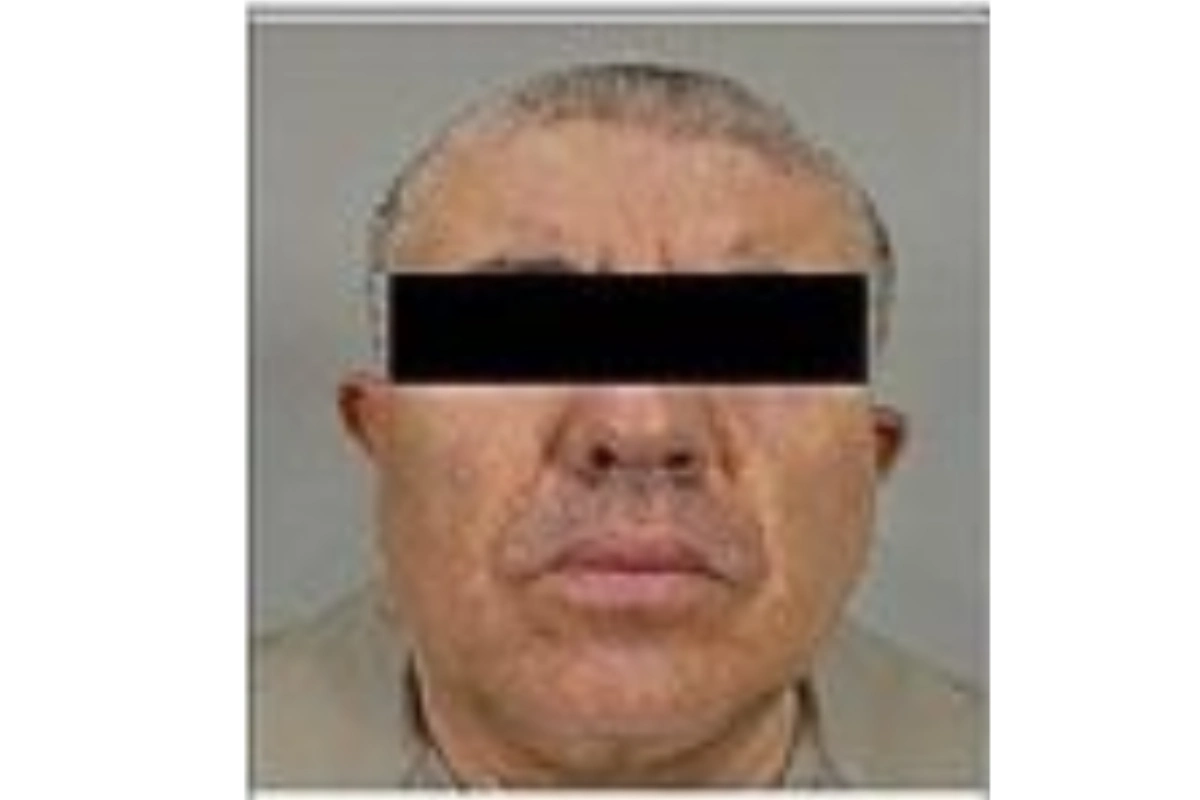 Un hombre con los ojos tapados y el cabello cano