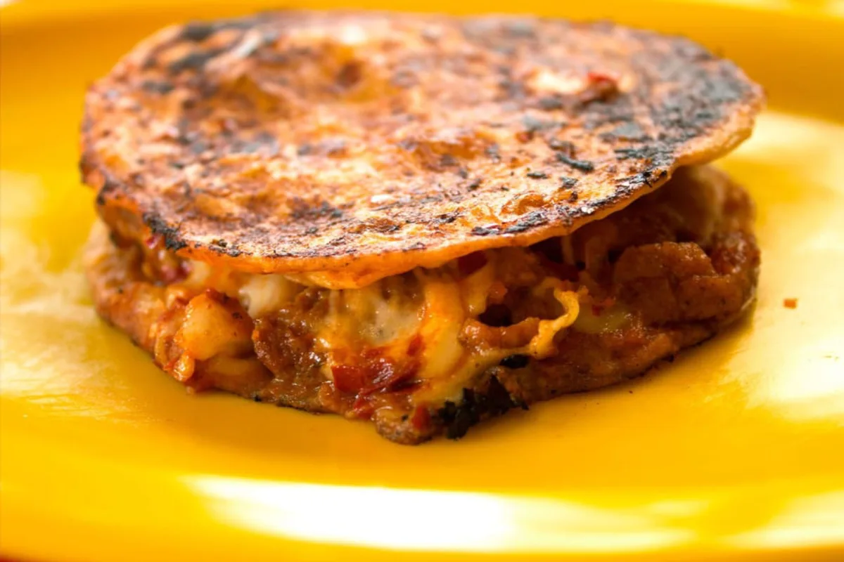 Dos quesadillas empalmadas con carne y queso en medio