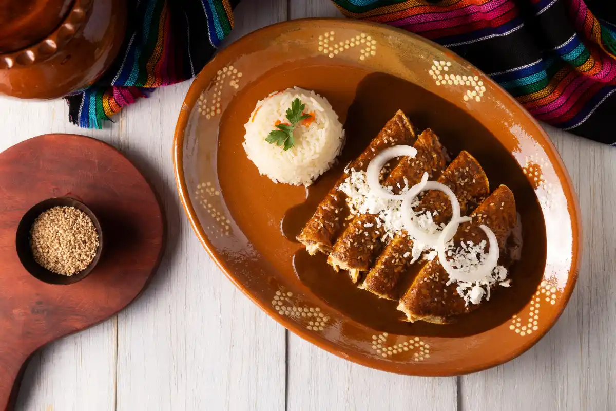 En plato de barro están servidas cuatro enchiladas y bañadas con salsa de huitlacoche