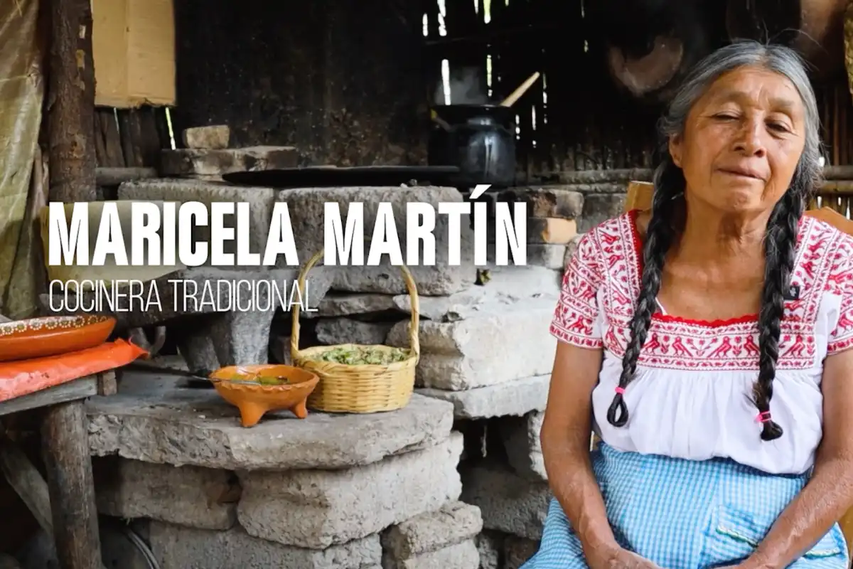 Mujer mayor sentada en una cocina tradicional