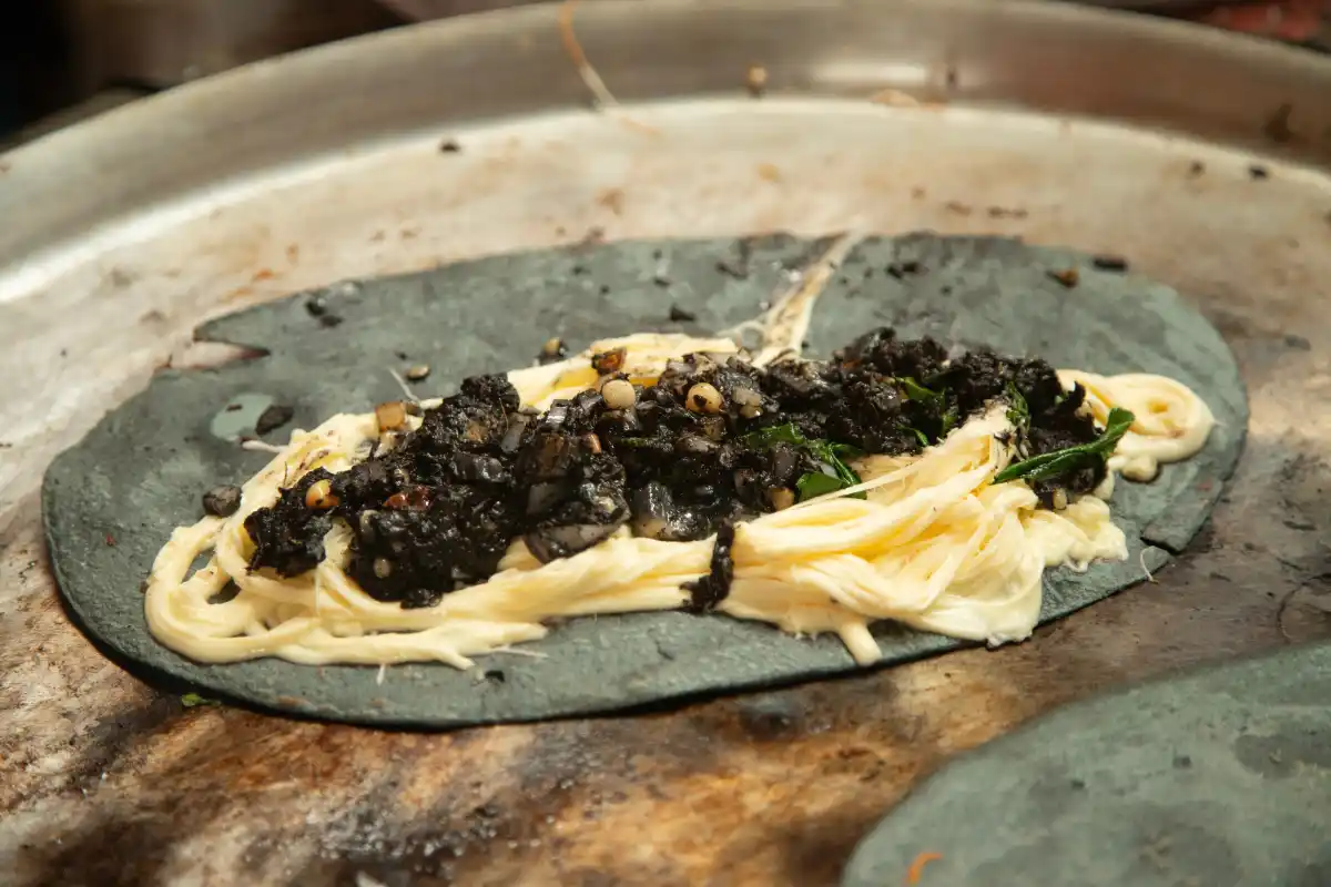 Tortilla de masa azul con huitlacoche y queso en su interior
