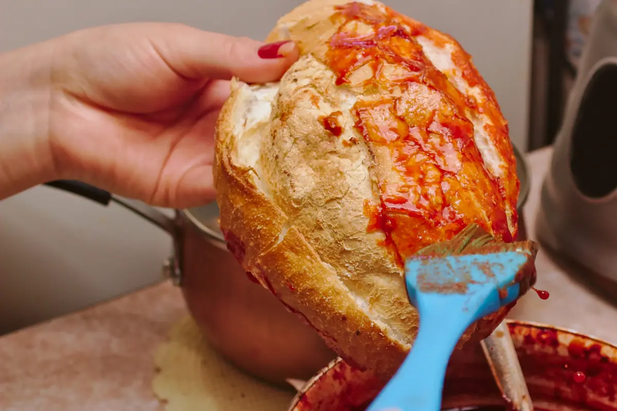 Mujer barniza con chile un pan 