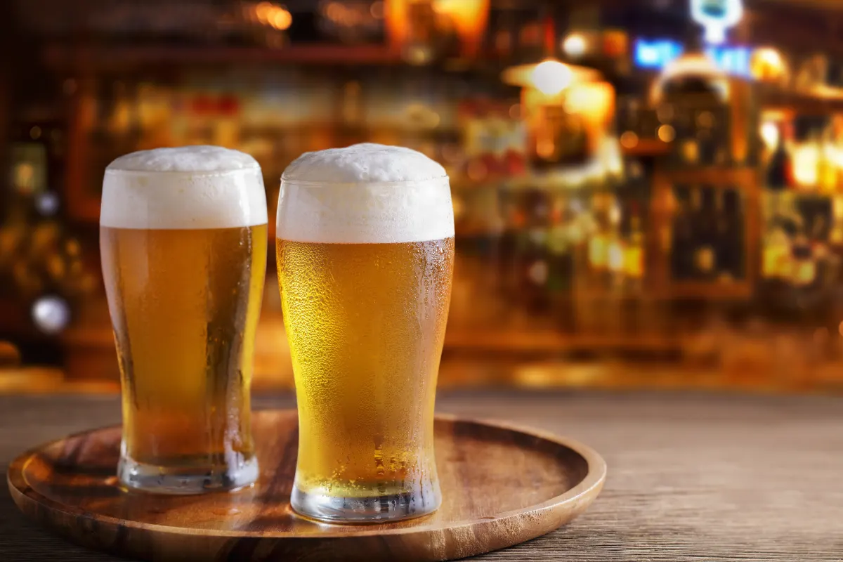 Dos vasos cerveceros servidos con cerveza clara
