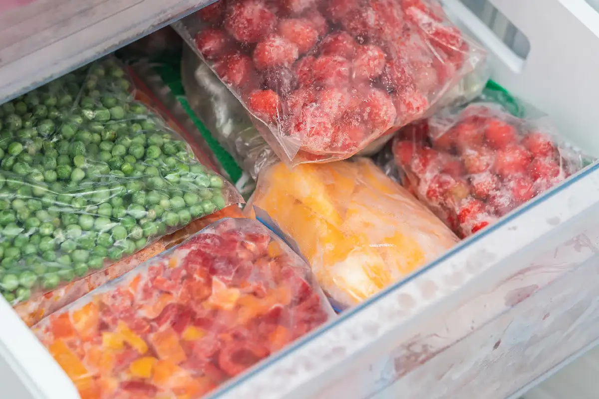 cajón de refrigerador con frutas y verduras congeladas