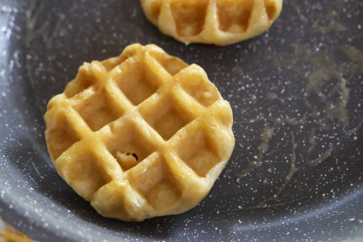 Sartén con mantequilla con dos pequeños waffles
