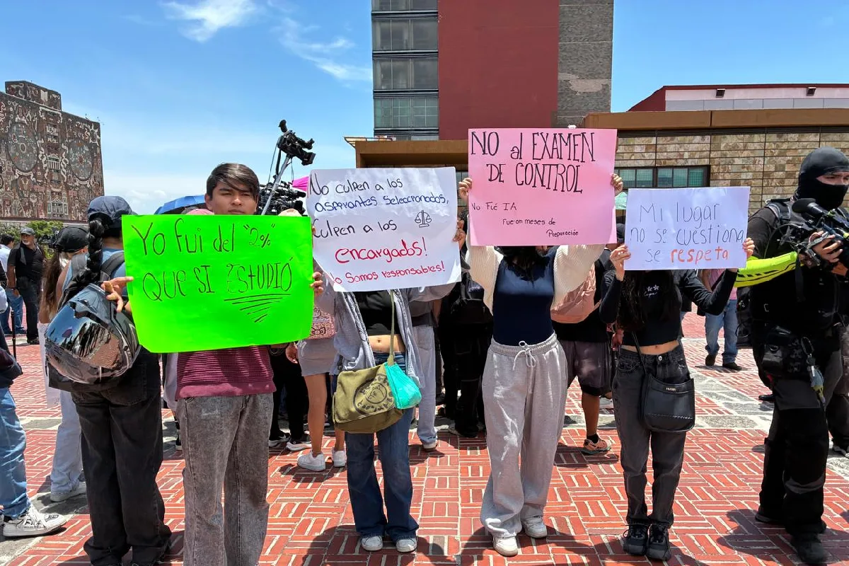 Manifestantes al exterior del edificio de Rectoría con carteles contra el examen presencial