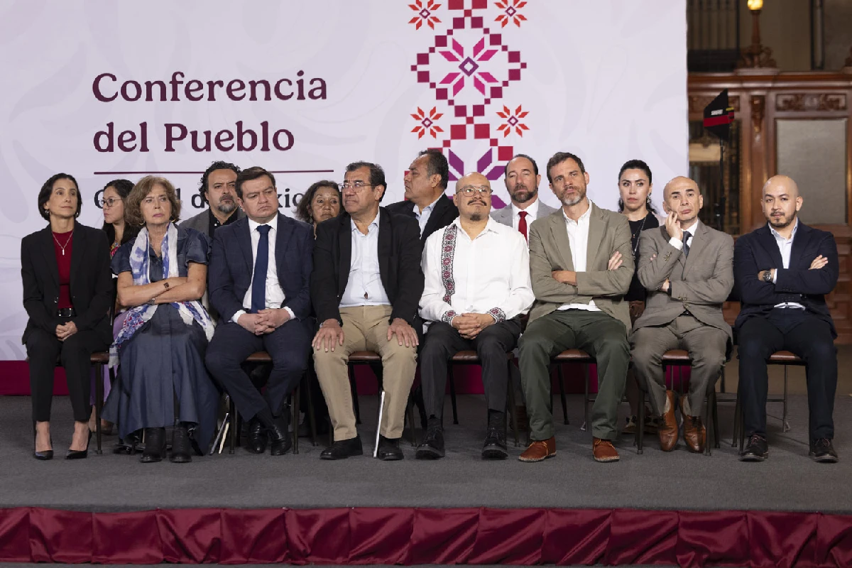 Grupo de hombres y mujeres sentados en la conferencia de prensa matutina