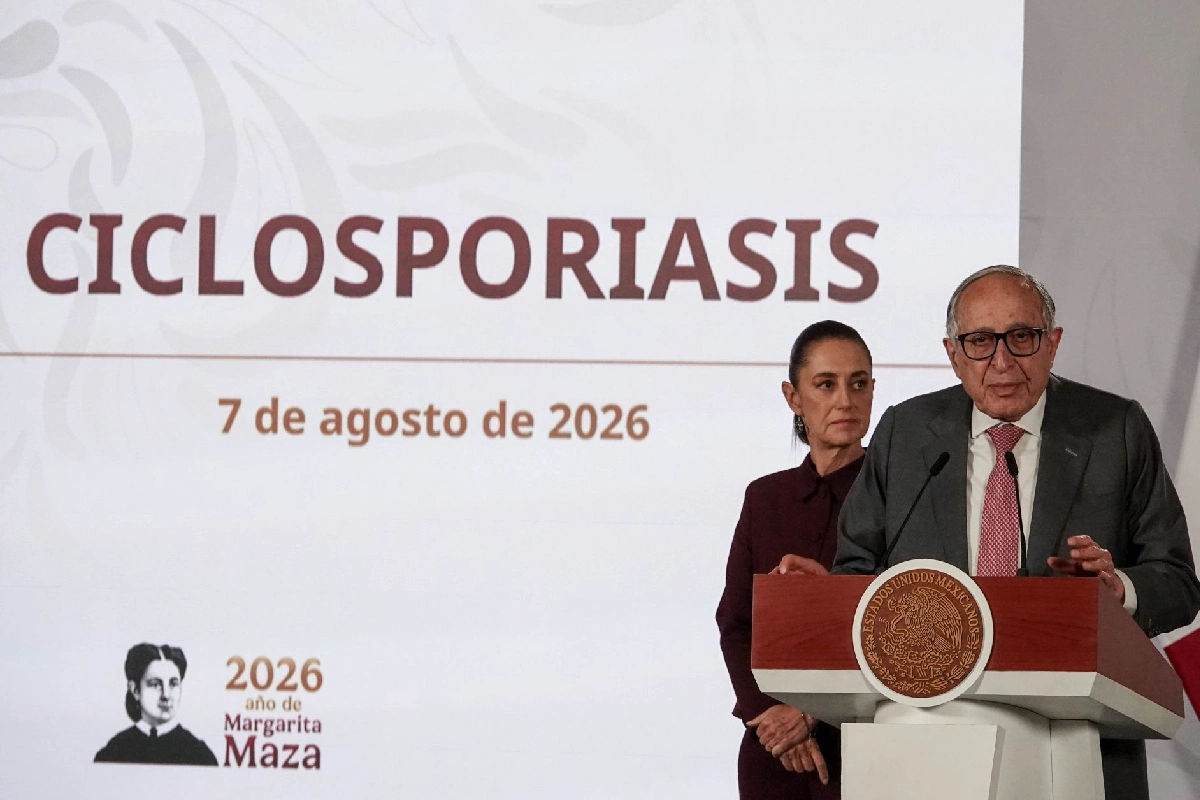 David Kershenobich hablando desde el pódium presidencial junto a Claudia Sheinbaum, con una pantalla al fondo que muestra la palabra "CICLOSPORIASIS" y la fecha "7 de agosto de 2026".