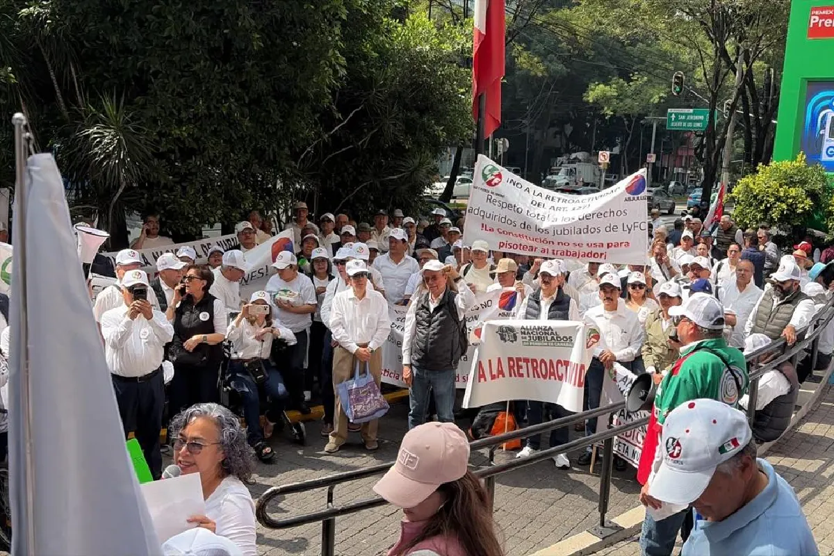 Jubilados vestidos de blanco sosteniendo pancartas 