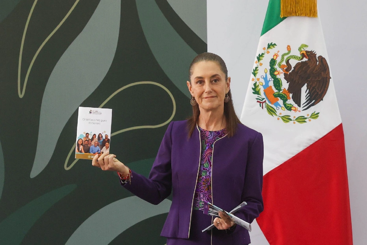 Presidenta Claudia Sheinbuam sosteniendo una guía del abc de las emociones