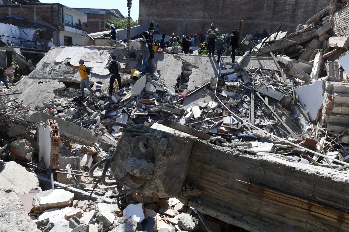 Rescatistas y voluntarios buscando supervivientes entre los escombros de un edificio colapsado.