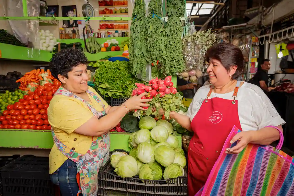 Dos mujeres sonrientes en un mercado mexicano