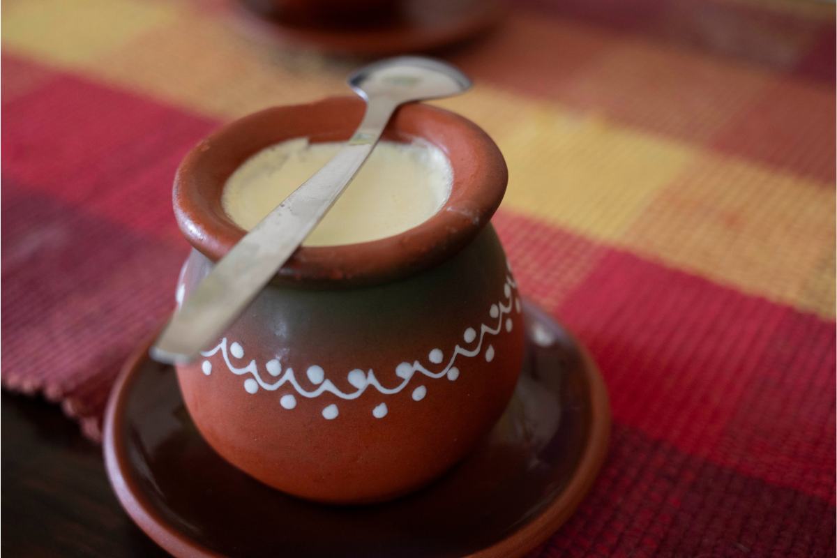 Taza de barro con atole en su interior