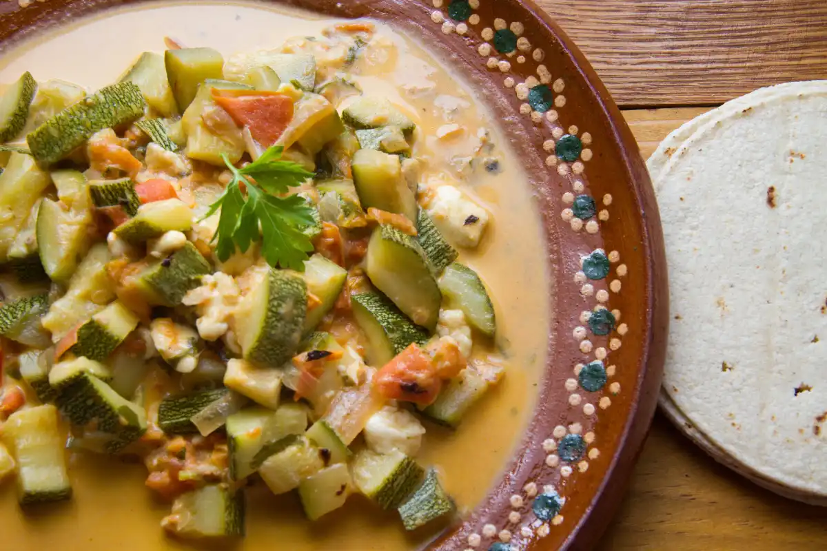 Plato de barro con calabacitas a la mexicana acompañadas con tortillas de maíz