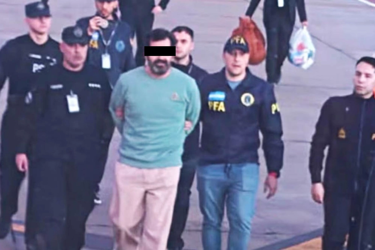 Fernando Farías Laguna detenido rondeado de policías usando un suter verde