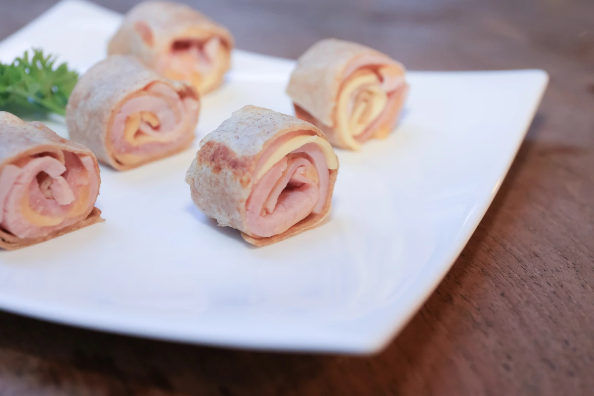 Plato blanco con rollitos de jamón y queso