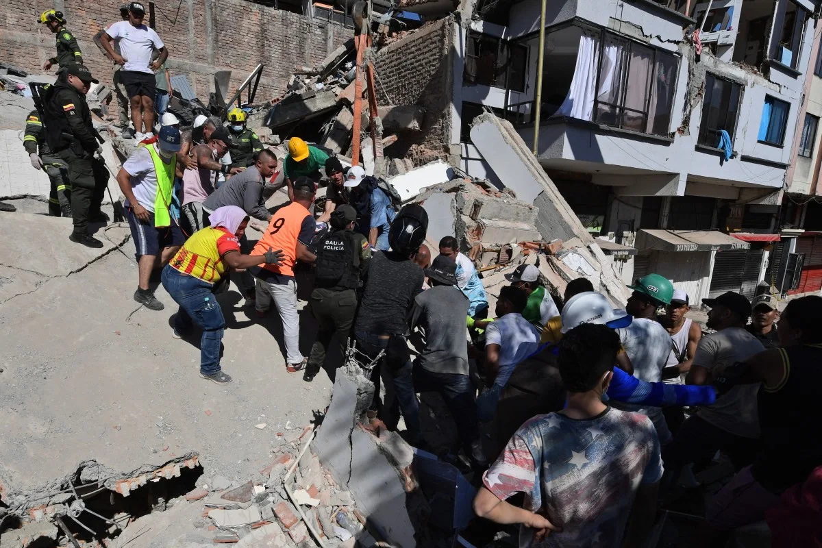 Los rescatistas arman cadenas humanas para sacar los restos del edificio