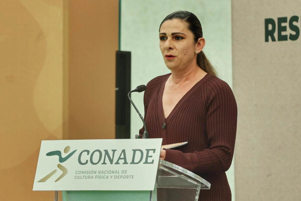 Ana Guevara en conferencia de prensa con un atril con el logo de la conade