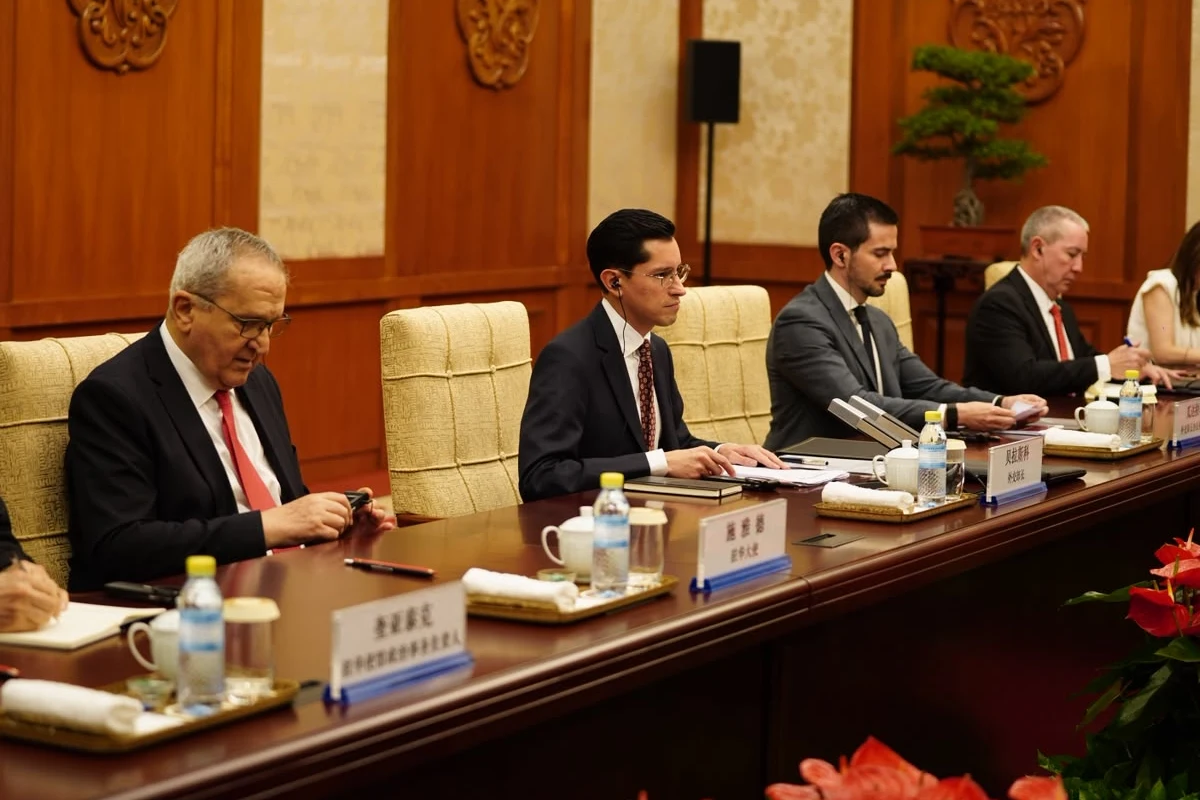 Roberto Velasco Álvarez, jefe de la Unidad para América del Norte de la SRE, junto a delegados mexicanos en una mesa de reuniones oficial con identificadores de nombre en chino y español.