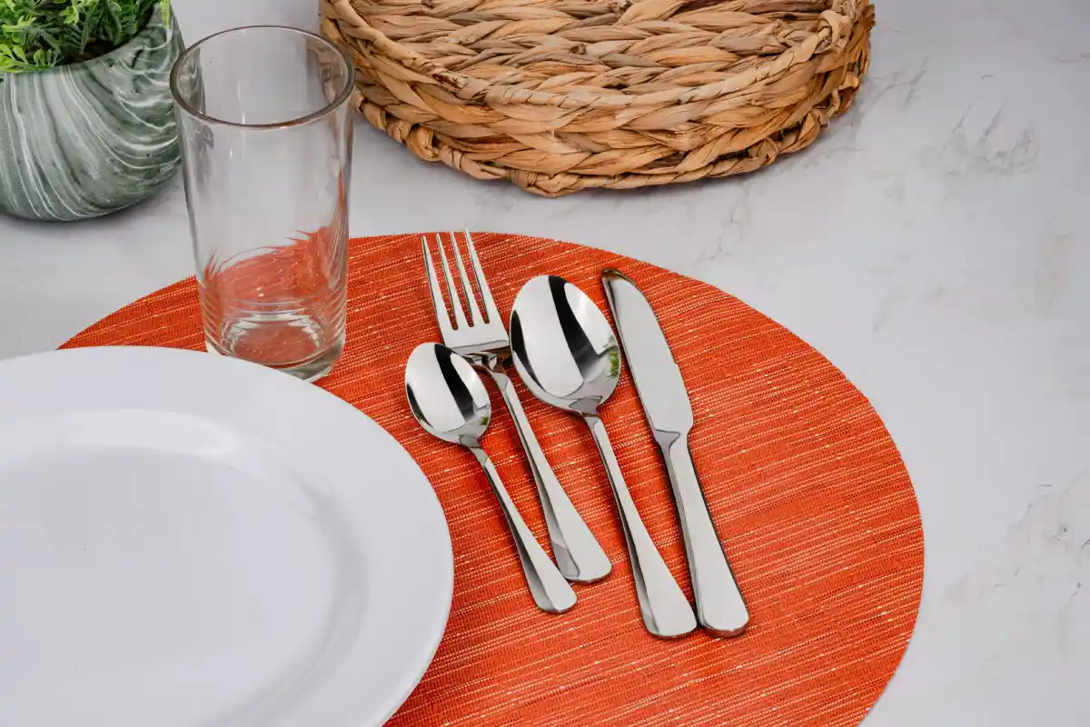 Mesa puesta para comer con cubiertos, vaso y plato